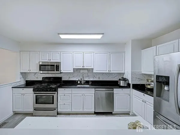 a kitchen with stainless steel appliances a stove a sink a stove a microwave and cabinets