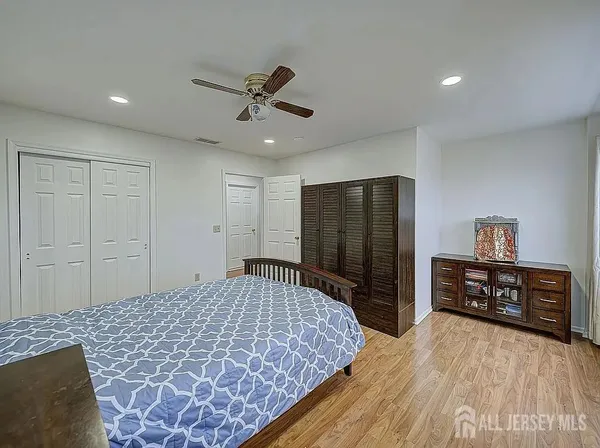 a bedroom with a bed and dresser with mirror