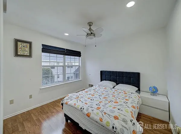 a bedroom with a bed a dresser and next to a window