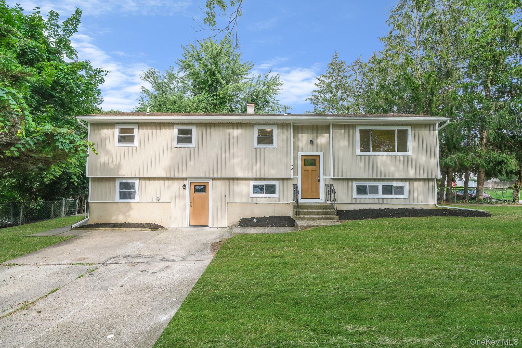 a front view of a house with a yard and trees