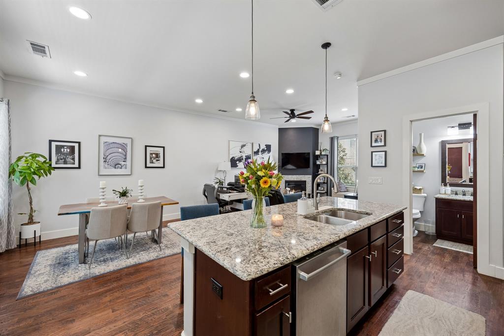 5875 Ross Avenue, Unit 9 Dallas, TX 75206 - Photo 29 of 29 Kitchen featuring dark wood finish cabinetry, light stone counters, open floor plan, dark wood finished floors, and crown molding