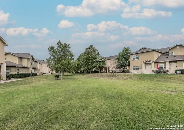 a view of a big house with a big yard and large trees