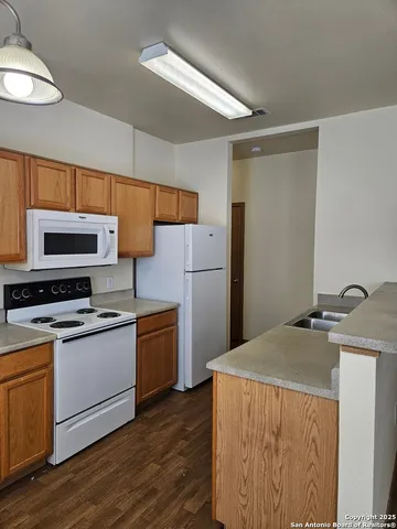 a kitchen with stainless steel appliances a refrigerator a stove a sink and white cabinets