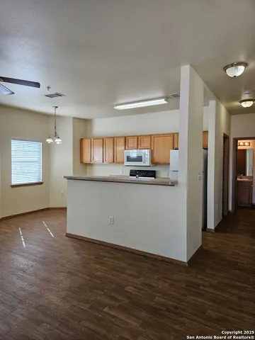 a view of a kitchen with wooden floor and electronic appliances