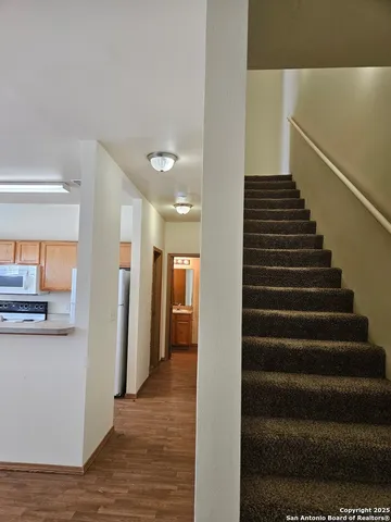 a view of a hallway with wooden floor and entryway