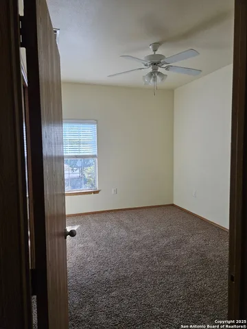 a view of a hallway with a chandelier fan