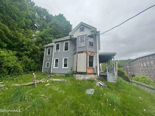 a view of a house with a yard and sitting area