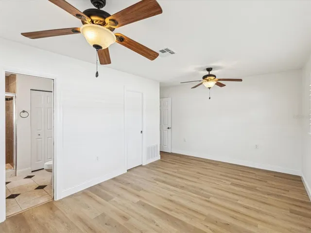 a view of a room with wooden floor and ceiling fan
