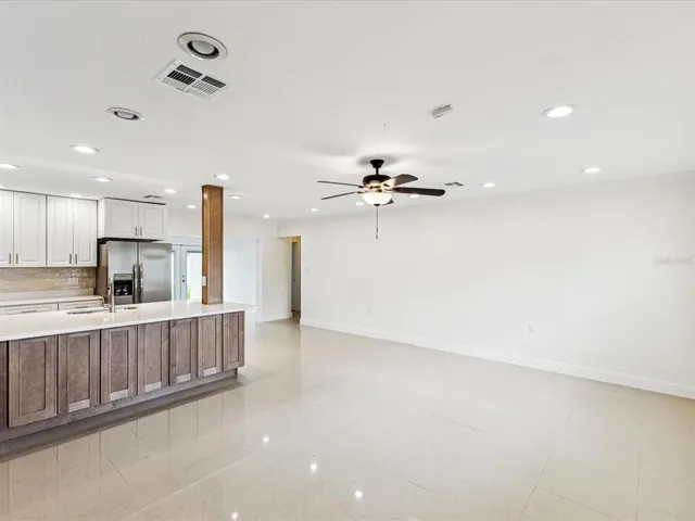 a view of kitchen with a sink refrigerator and window