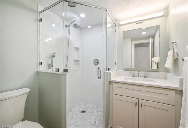 a bathroom with a sink a toilet and shower