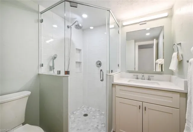 a bathroom with a sink a toilet and shower