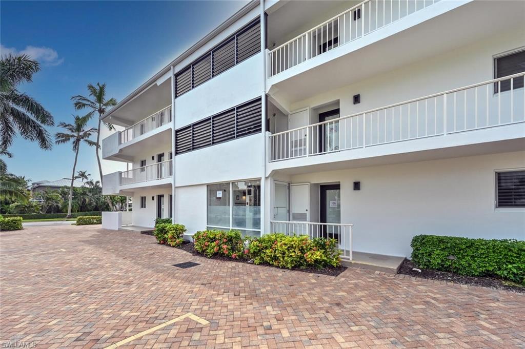 250 7th Avenue South, Unit 301 Naples, FL 34102 - Photo 16 of 21 a front view of a building with garden and plants