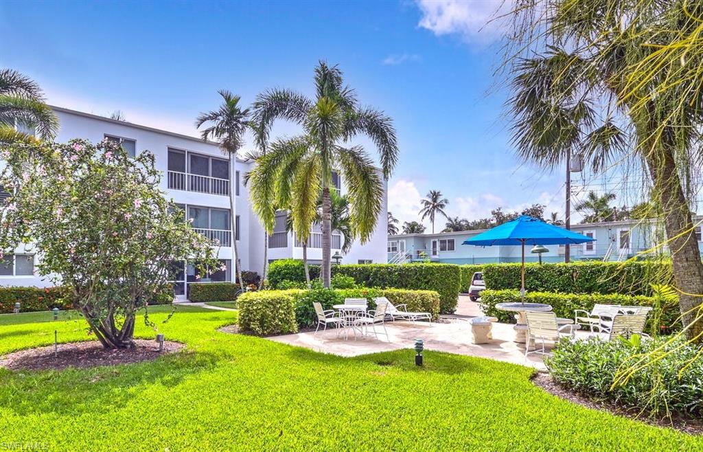 250 7th Avenue South, Unit 301 Naples, FL 34102 - Photo 18 of 21 a view of a swimming pool with a garden and patio