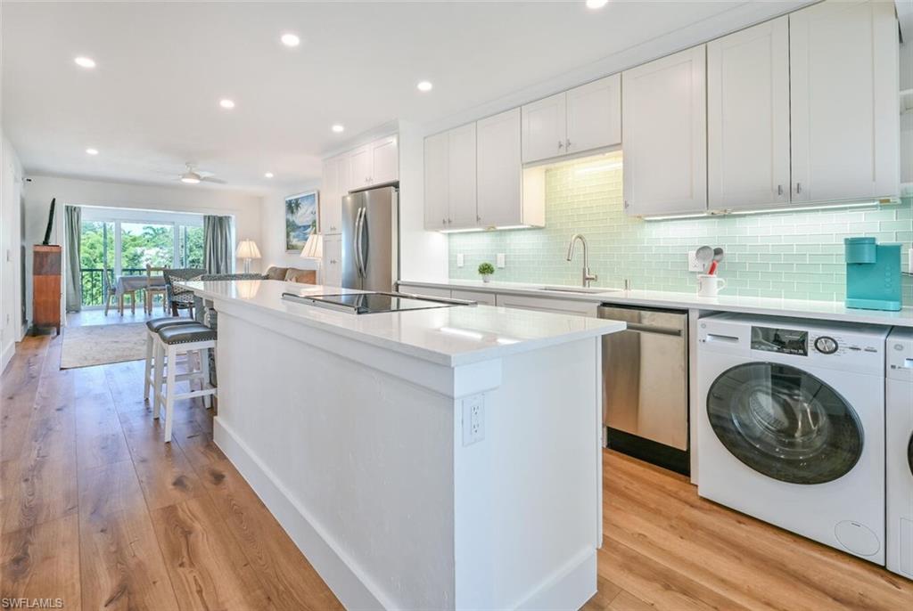 250 7th Avenue South, Unit 301 Naples, FL 34102 - Photo 4 of 21 a kitchen with cabinets and wooden floor
