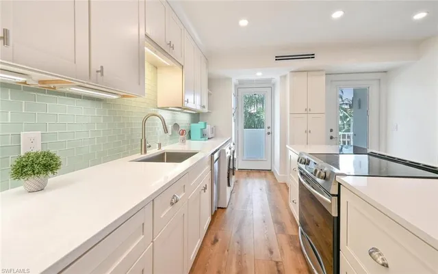 a kitchen with a sink a stove and cabinets
