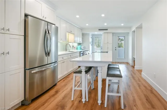 a kitchen with kitchen island wooden floor center island and stainless steel appliances