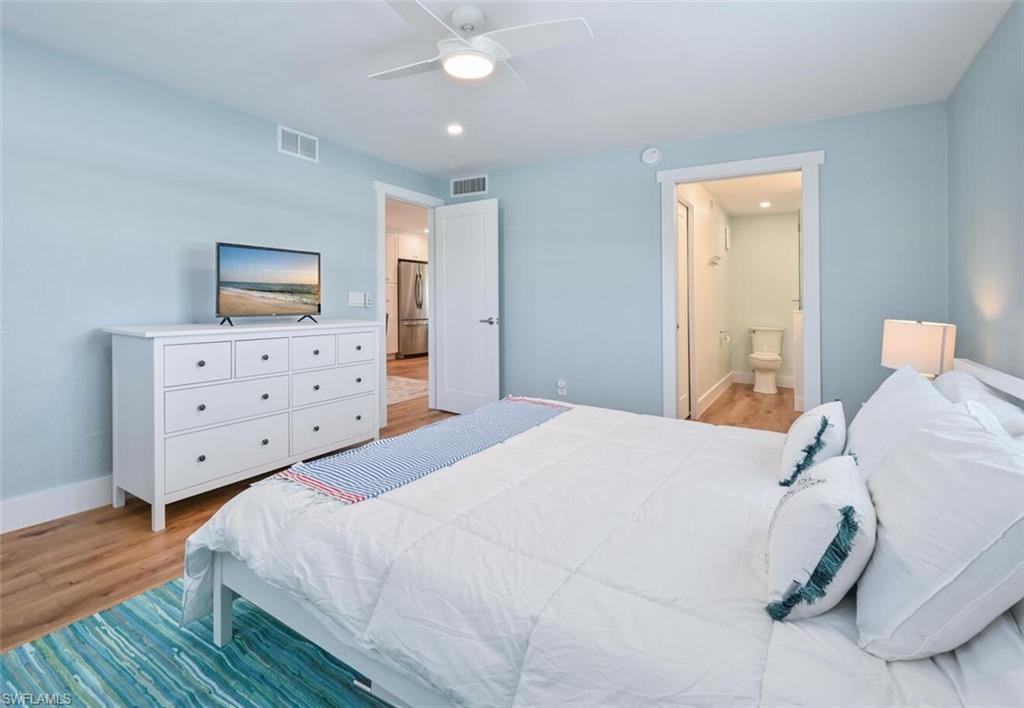 250 7th Avenue South, Unit 301 Naples, FL 34102 - Photo 10 of 21 a bedroom with a bed and wooden floor