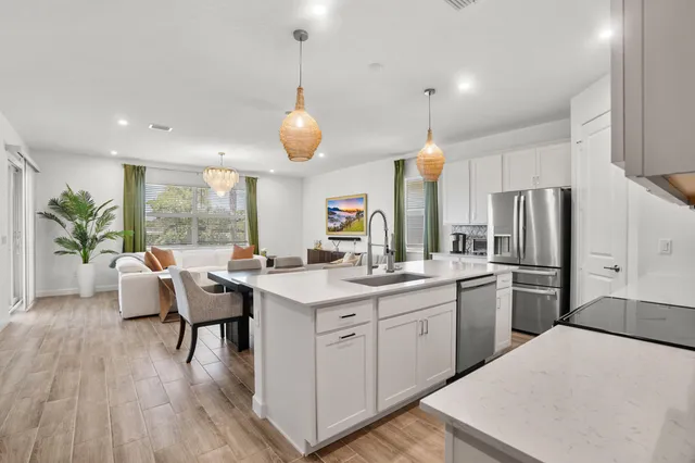 a kitchen with a table chairs refrigerator and microwave