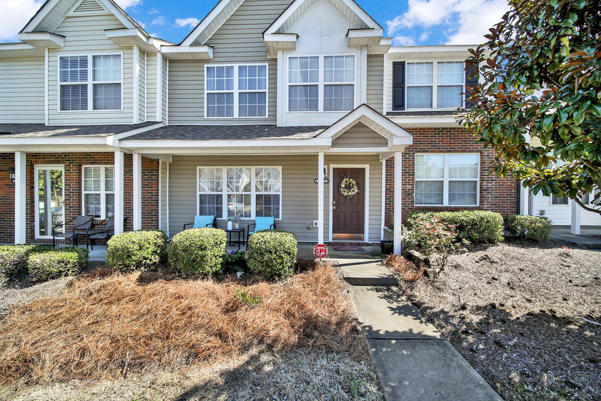 a front view of a house with a yard and potted plants