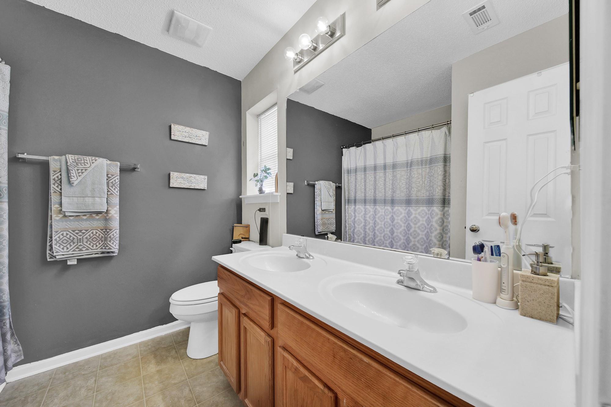 11223 Grass Field Road Charlotte, NC 28213 - Photo 12 of 25 a bathroom with a double vanity sink mirror and toilet