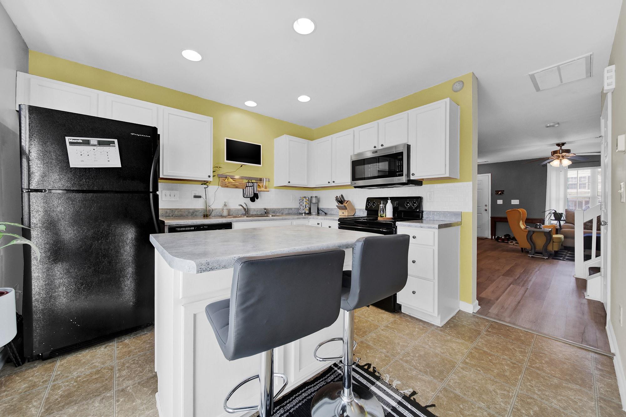11223 Grass Field Road Charlotte, NC 28213 - Photo 19 of 25 a kitchen with stainless steel appliances kitchen island sink refrigerator and microwave