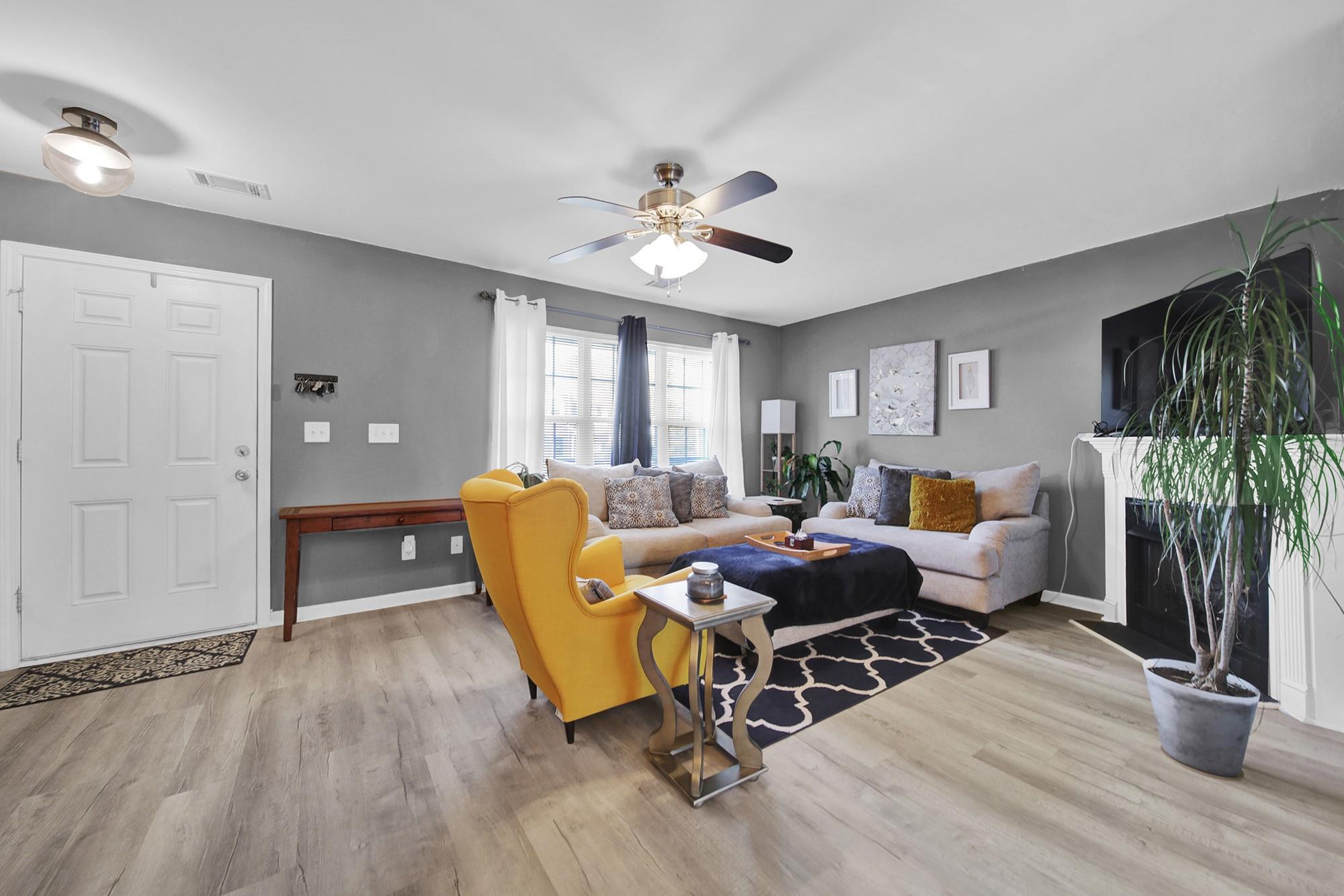 11223 Grass Field Road Charlotte, NC 28213 - Photo 6 of 25 a living room with furniture a fireplace and a flat screen tv