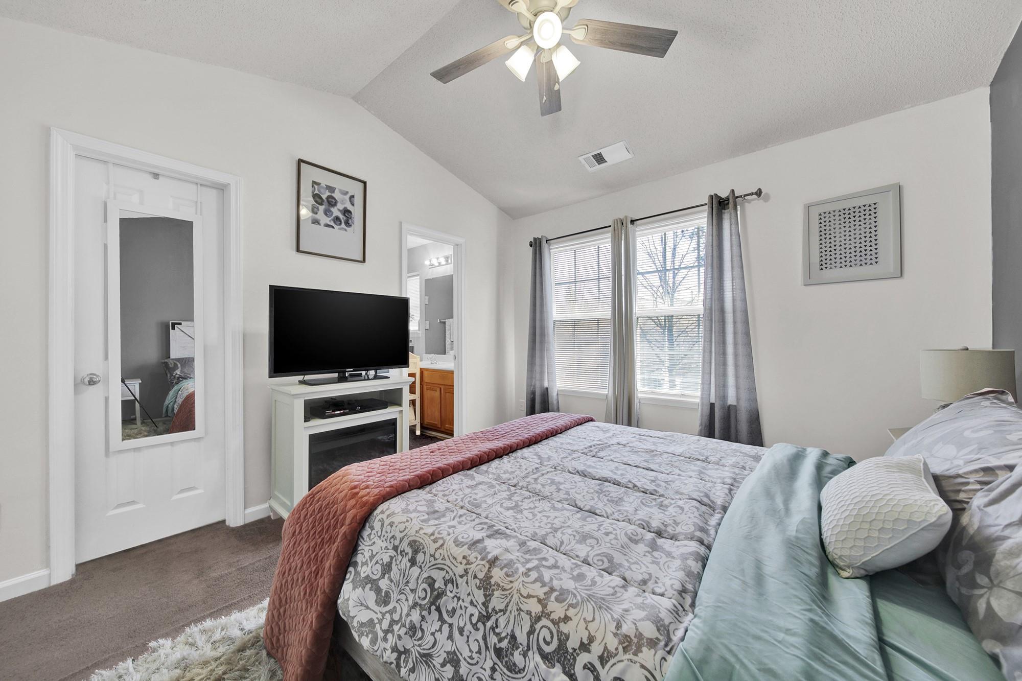 11223 Grass Field Road Charlotte, NC 28213 - Photo 10 of 25 a bedroom with a bed and a flat screen tv