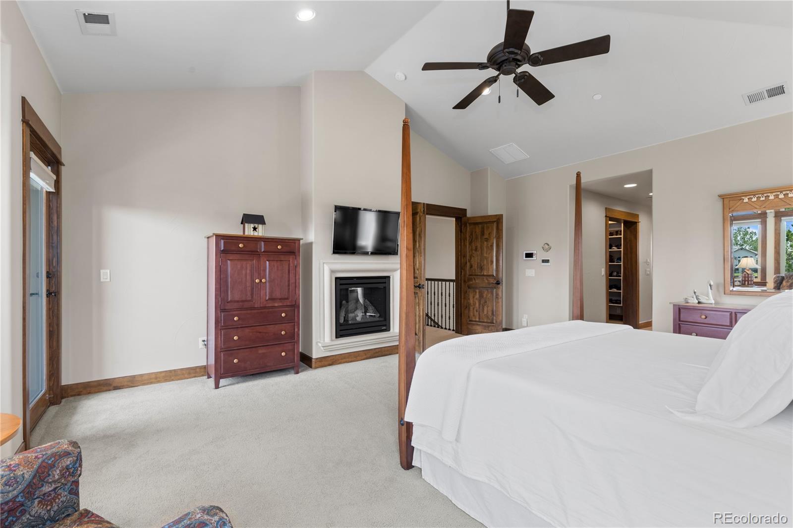 1291 Buffalo Ridge Road Castle Pines, CO 80108 - Photo 20 of 39 a bedroom with a bed dresser and a flat tv screen