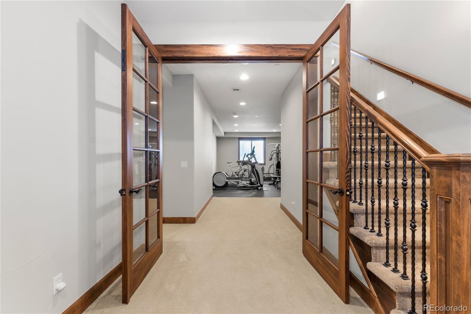 1291 Buffalo Ridge Road Castle Pines, CO 80108 - Photo 28 of 39 a view of a hallway with wooden floor and staircase