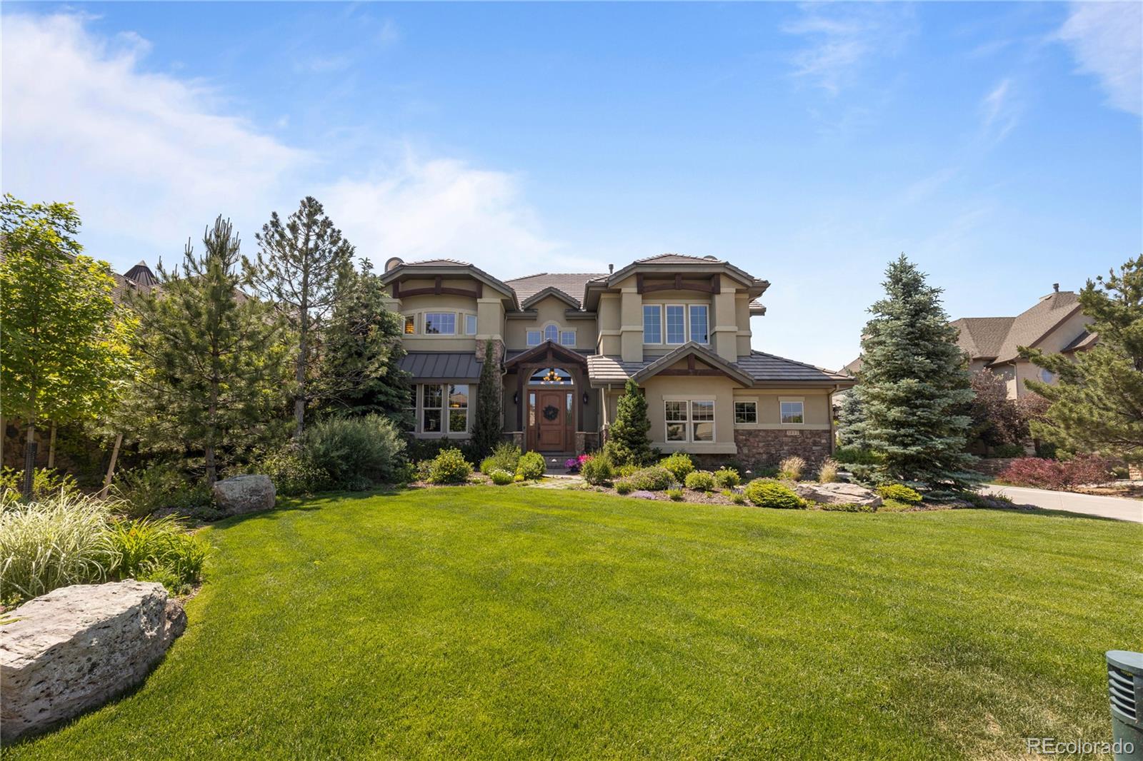 1291 Buffalo Ridge Road Castle Pines, CO 80108 - Photo 33 of 39 a front view of house with yard and trees in the background