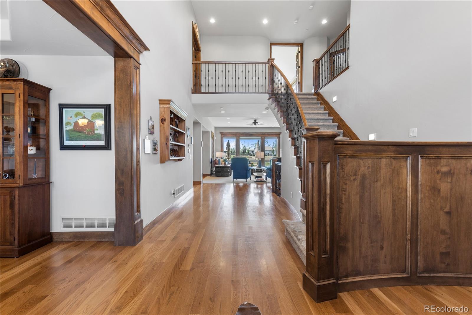 1291 Buffalo Ridge Road Castle Pines, CO 80108 - Photo 5 of 39 a view of a hallway with wooden floor and staircase