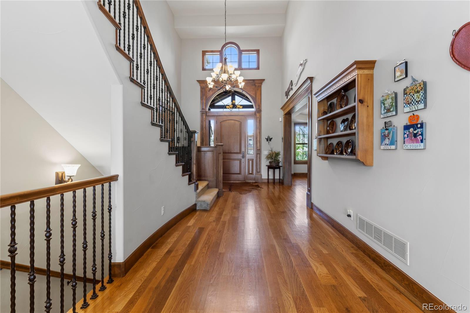 1291 Buffalo Ridge Road Castle Pines, CO 80108 - Photo 6 of 39 a view of a hallway with wooden floor and staircase