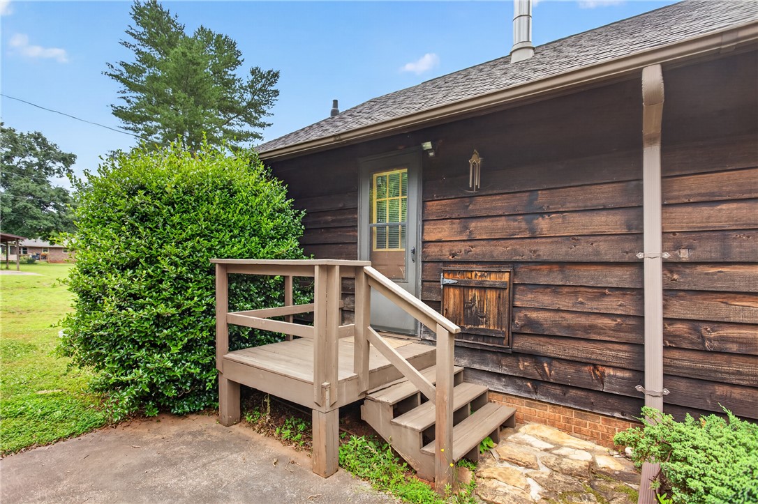 112 Holliday Lane Pendleton, SC 29670 - Photo 34 of 42 A charming wooden-sided home offers a welcoming entrance with a compact deck and stairs.