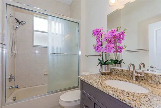 a bathroom with a granite countertop sink a shower and a mirror