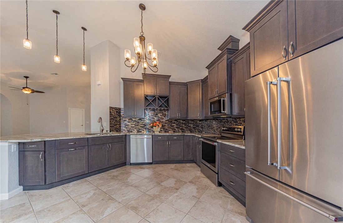 5952 Spanish River Road Fort Pierce, FL 34951 - Photo 7 of 35 a kitchen with stainless steel appliances granite countertop a refrigerator and a sink