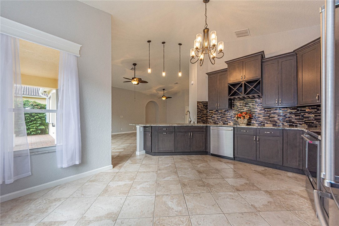 5952 Spanish River Road Fort Pierce, FL 34951 - Photo 9 of 35 a large kitchen with kitchen island granite countertop a stove a sink a counter space and cabinets