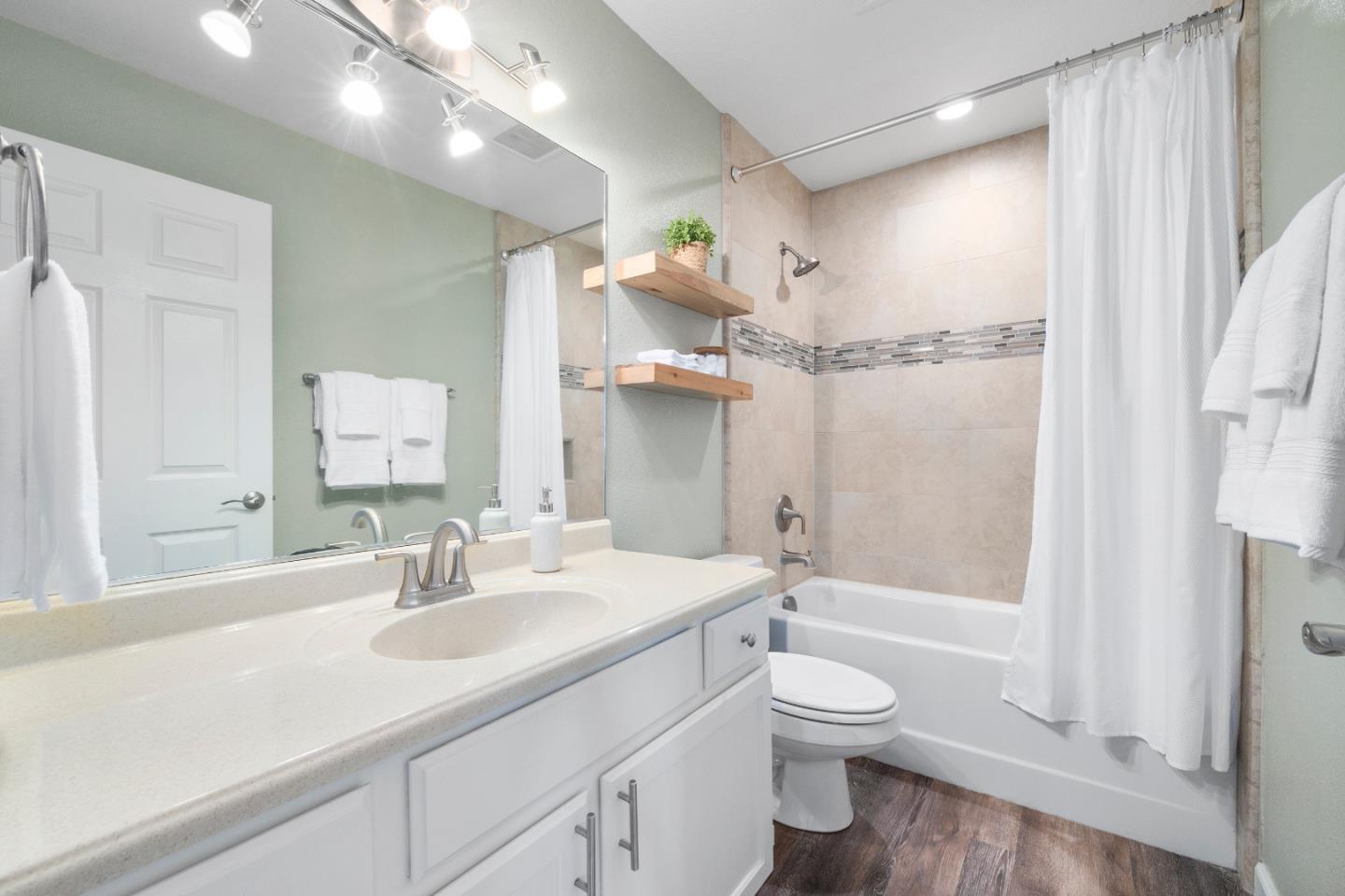 164 Weeks Drive Watsonville, CA 95076 - Photo 18 of 37 a bathroom with a granite countertop sink toilet a large mirror a bathtub and shower
