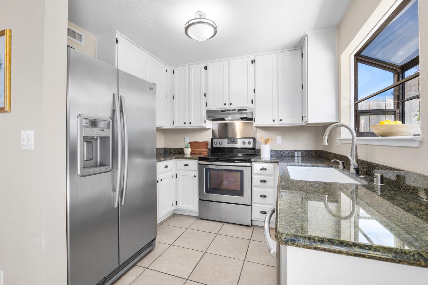 164 Weeks Drive Watsonville, CA 95076 - Photo 7 of 37 a kitchen with granite countertop a refrigerator sink stove and cabinets