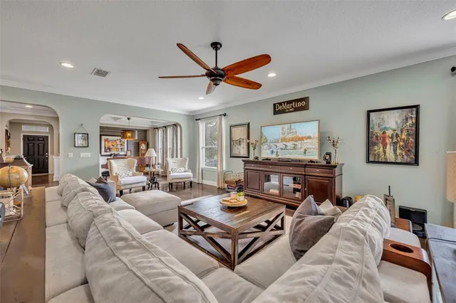 a living room with furniture a ceiling fan and a rug