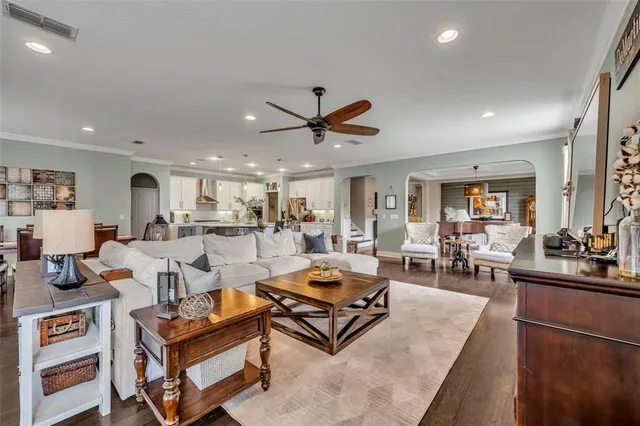 a living room with furniture kitchen view and a chandelier