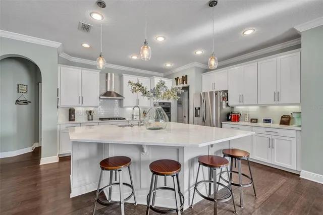 a large white kitchen with lots of counter space and stainless steel appliances
