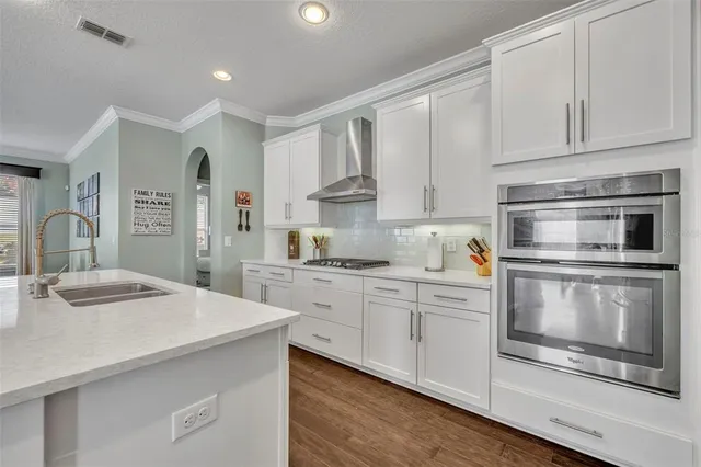 a kitchen with granite countertop white cabinets and appliances