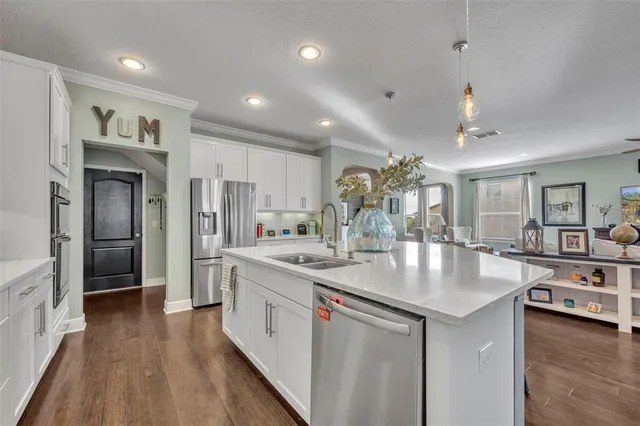 a kitchen with stainless steel appliances granite countertop a sink refrigerator and cabinets