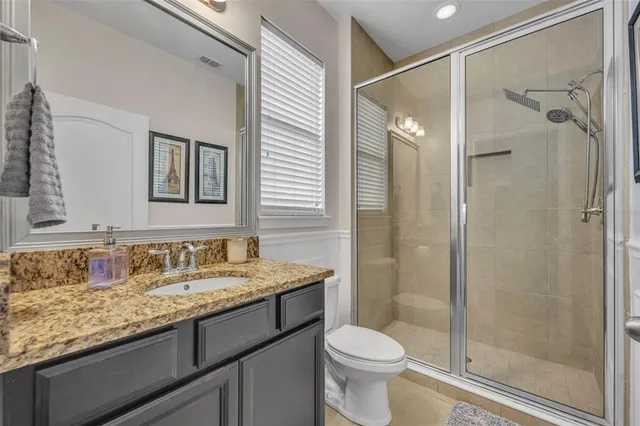 a bathroom with a granite countertop sink toilet and shower