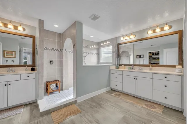 a spacious bathroom with a granite countertop sink mirror and shower