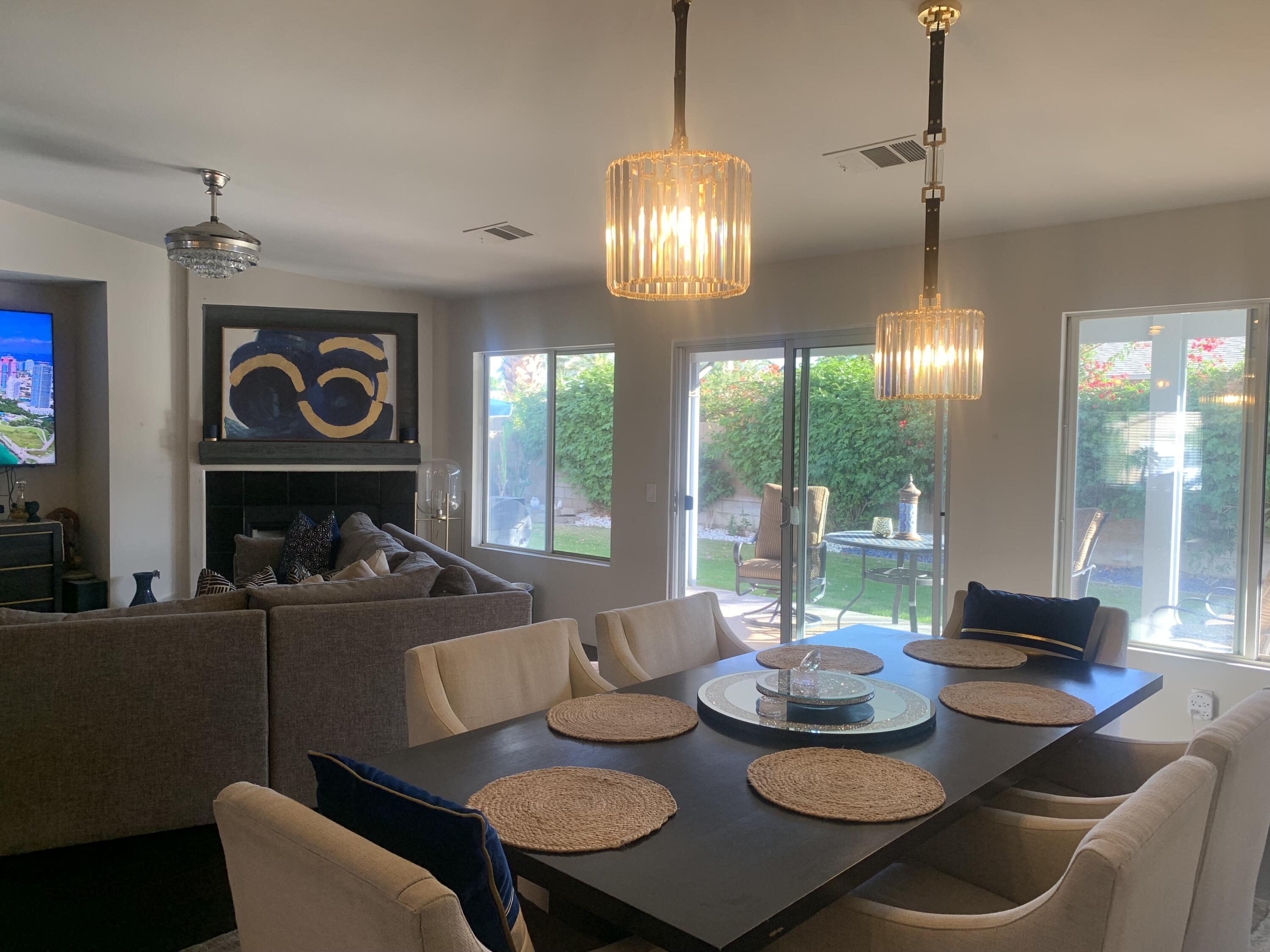 81059 Aurora Avenue Indio, CA 92201 - Photo 14 of 26 a view of a dining room with furniture large windows and wooden floor