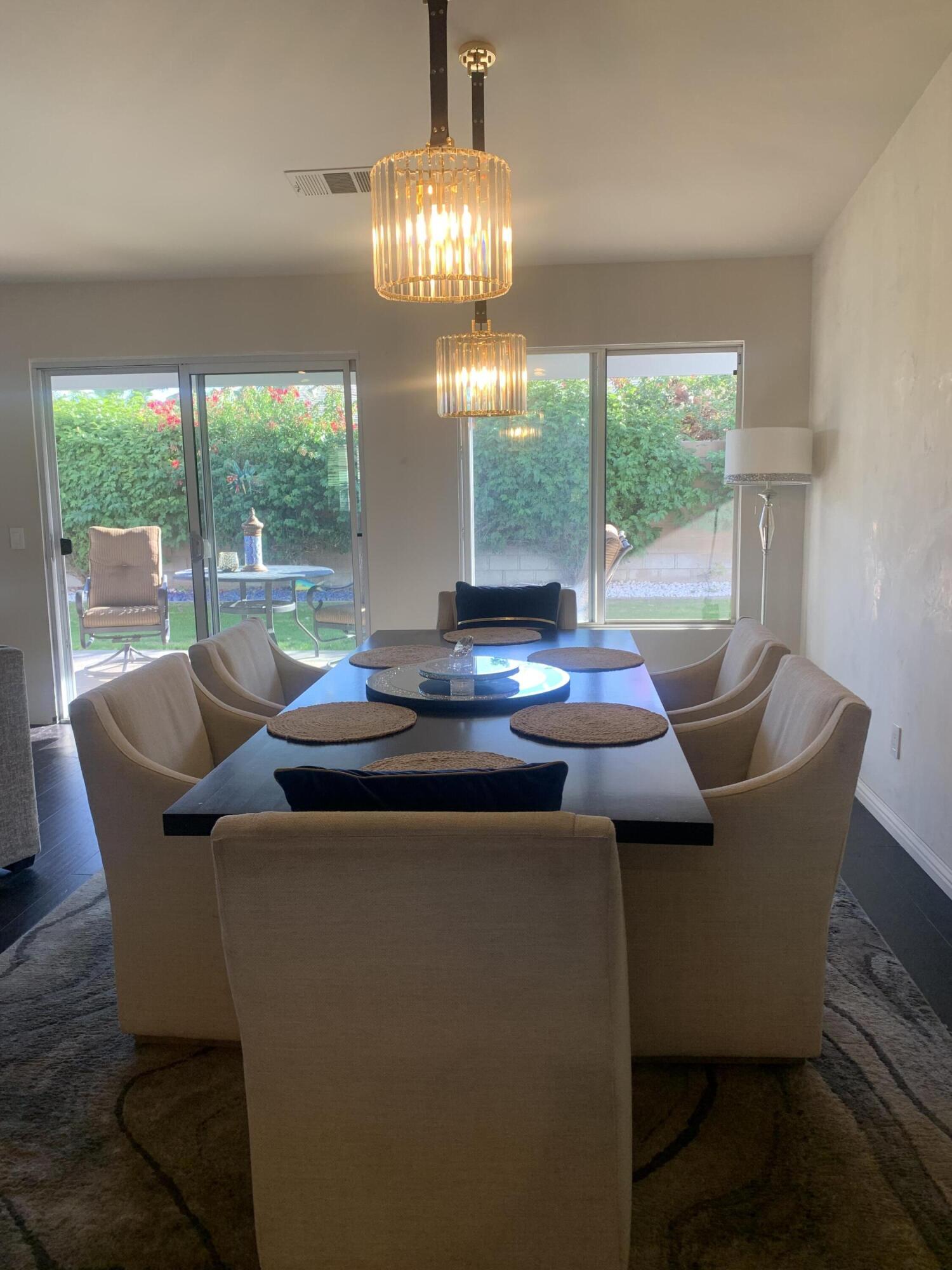 81059 Aurora Avenue Indio, CA 92201 - Photo 15 of 26 a view of a dining room with furniture wooden floor and a chandelier