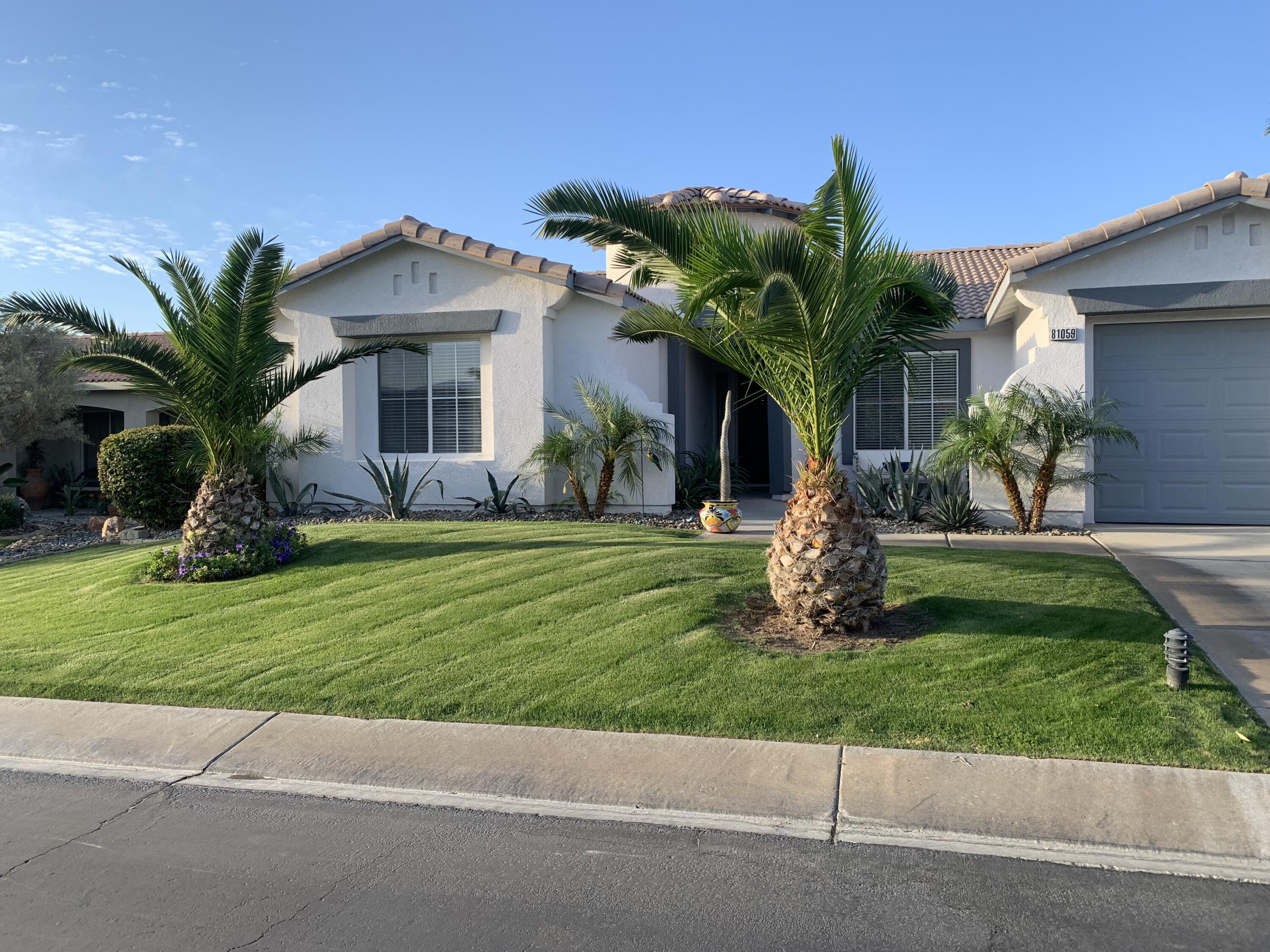 81059 Aurora Avenue Indio, CA 92201 - Photo 2 of 26 a front view of a house with a garden and plants