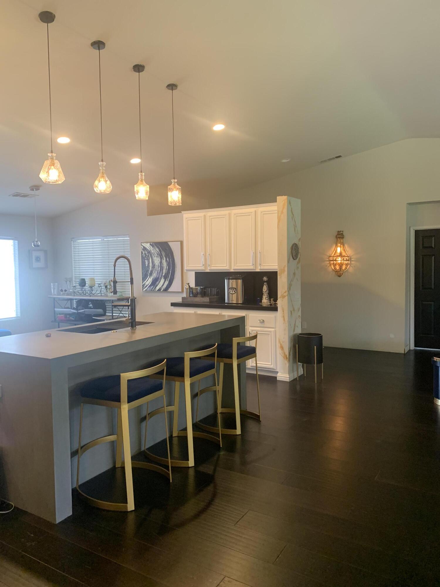 81059 Aurora Avenue Indio, CA 92201 - Photo 24 of 26 a kitchen with stainless steel appliances granite countertop a stove a sink a dining table and chairs with wooden floor