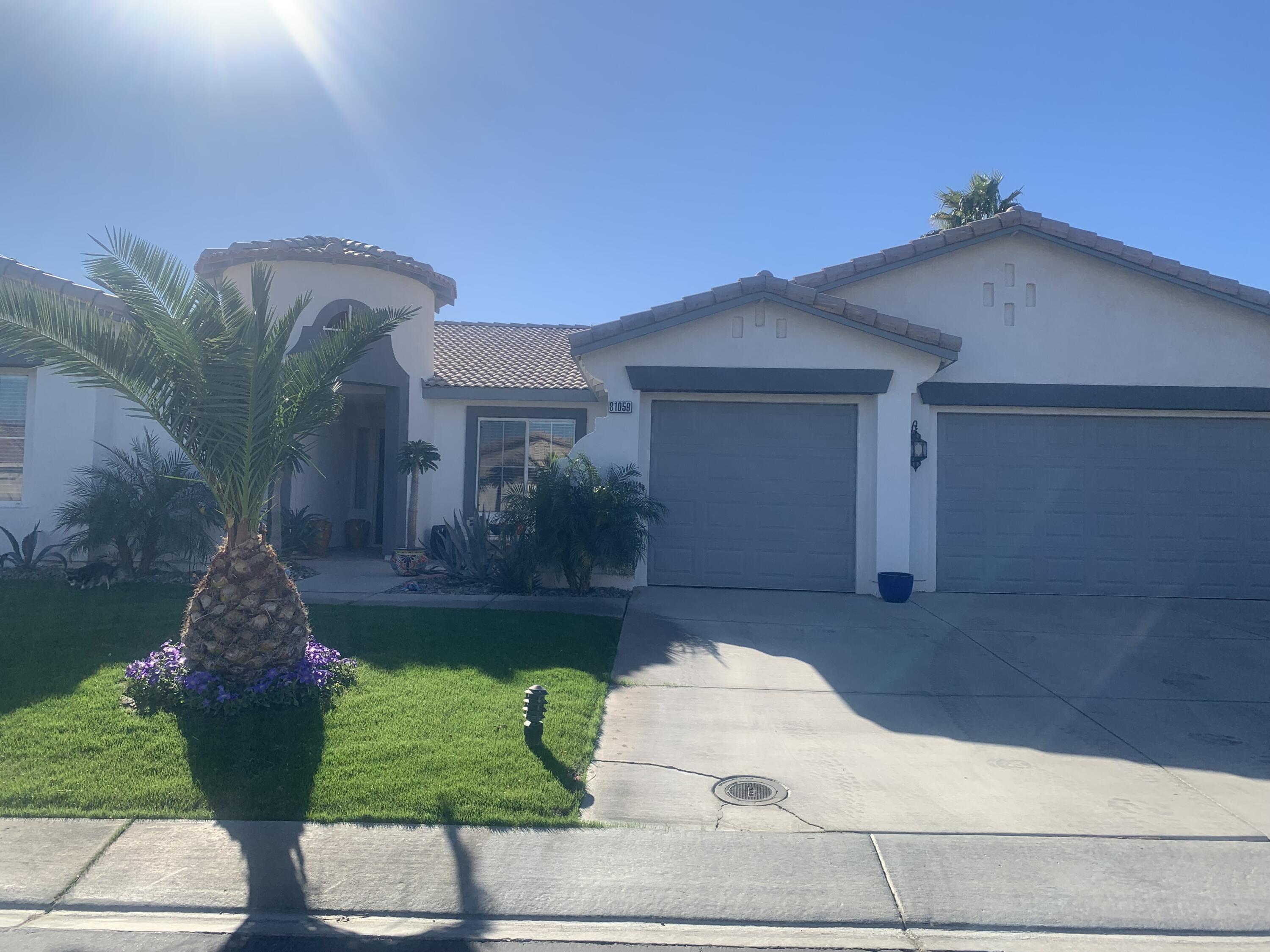 81059 Aurora Avenue Indio, CA 92201 - Photo 8 of 26 a front view of a house with a yard and garage